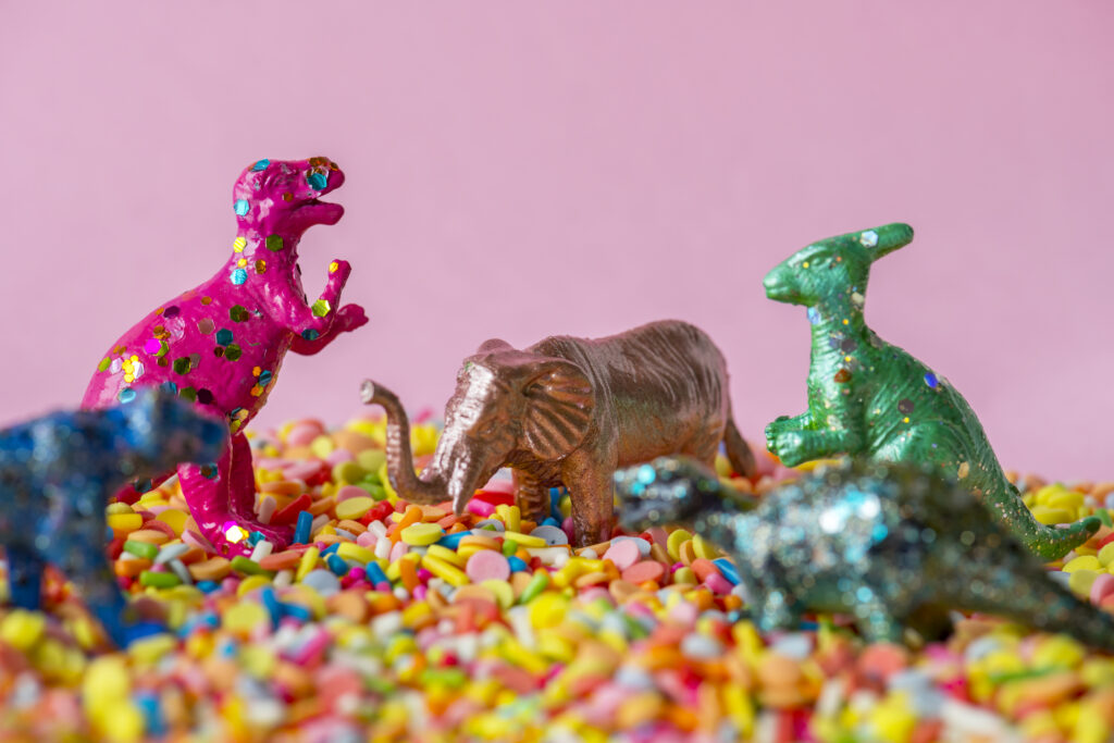 close up dinosaurs animal figure toys sweet candy sprinkles